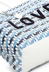 Borsa intrecciata bianca, blu e nera con la scritta "LOVE" in tessuto scuro. Presenta una catena argentata per il trasporto e una superficie texturizzata.