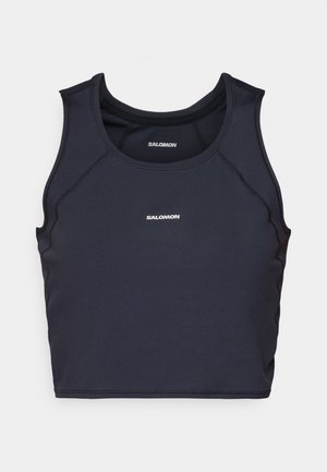 Črn športni tank top s prilegajočim dizajnom, okroglim izrezom in ravnimi šivi. Na sprednji strani ima bel logotip "Salomon".