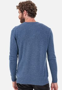 Pull bleu tricoté avec un col rond, des poignets et un ourlet côtelés, doté d'une texture douce et d'une coupe classique.