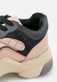 Chunky sneaker with a mix of pink leather, black suede, and mesh textile. Features reinforced sole, textured accents, and brand logo.