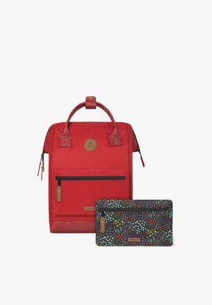 Roter Polyester-Rucksack mit strukturierter Oberfläche, obenem Tragegriff, Vordertasche mit Reißverschluss und einer abnehmbaren schwarzen Tasche mit einem bunten Blumenmuster.