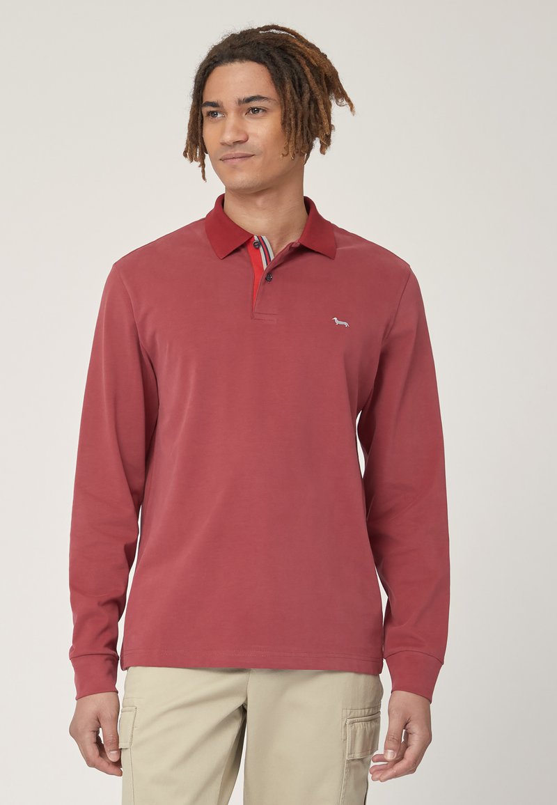 Polo a maniche lunghe di colore rosso con colletto, caratterizzato da una vestibilità slim, chiusura a bottoni e un piccolo logo sul lato sinistro del petto.
