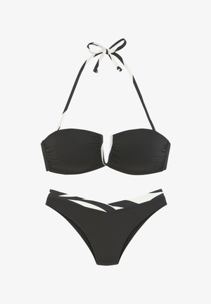Črn bikini komplet, ki vključuje bandeau zgornji del z naborki in odstranljivim vratnim trakom, v kombinaciji z nizkimi spodnjimi hlačkami, okrašenimi z belimi črtami.