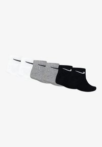 Paquete de seis calcetines en blanco, gris y negro. Cada calcetín presenta una textura acanalada y un logo en color contrastante en el lateral.