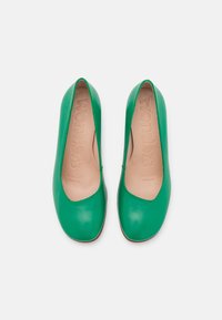 Escarpins en cuir vert avec un bout arrondi et une finition lisse. La doublure intérieure est beige avec le nom de la marque embossé. Design à talon bas.