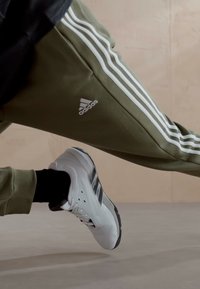 adidas Sportswear ESSENTIALS TAPERED CUFF 3-STRIPES  - Treniņtērpa apakšdaļas - olive strata