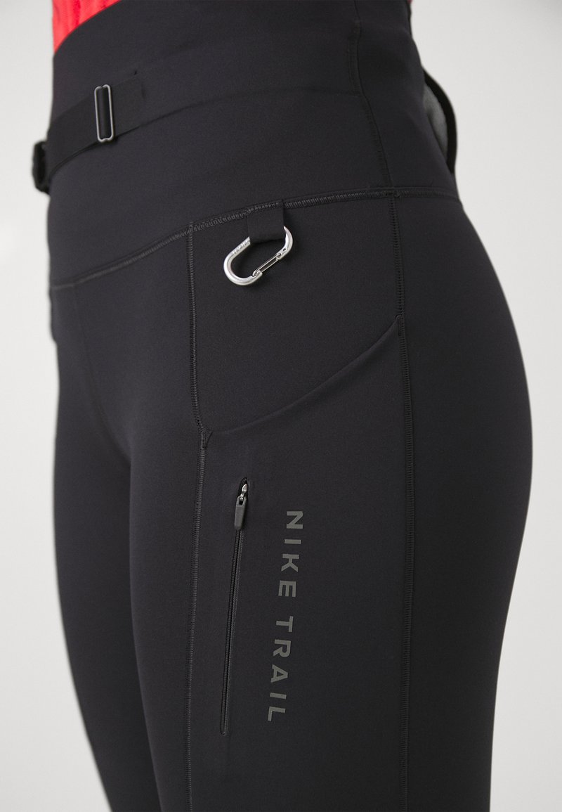 Les leggings de trail noirs Nike sont dotés d'une poche zippée, d'un logo réfléchissant et d'un détail de boucle en mousqueton, fabriqués à partir d'un matériau extensible évacuant l'humidité.