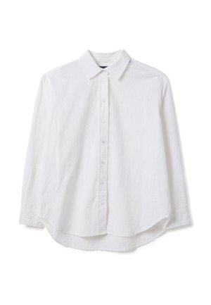 Camicia bianca a maniche lunghe con chiusura frontale con bottoni, orlo leggermente curvo e motivo strutturato. Realizzata in tessuto leggero con colletto classico.