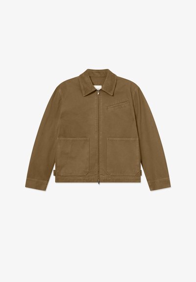 Ruskea takki, jossa on etuvetoketju, terävä kaulus ja kaksi suurta etutaskua. Varustettu pienellä rintataskulla ja suoralinjaisella helmalla.