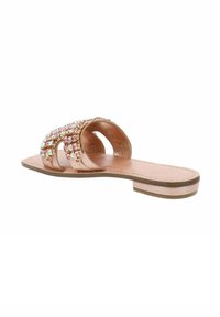 Infradito color oro rosa con decorazioni di gemme. Presentano una suola piatta, punta aperta e una finitura simile alla pelle liscia.