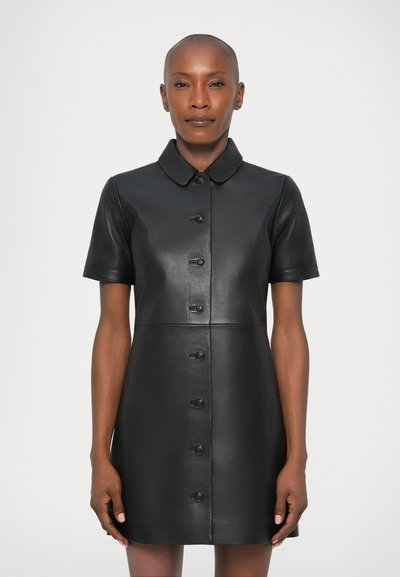 Black leather shirt dress with button-up front, short sleeves, and a tailored collar. Smooth texture and structured shape.