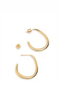 Pendientes de aro de oro con un diseño suave y curvado; un pendiente presenta un vástago cilíndrico, destacando el brillo metálico y las líneas continuas.