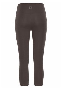 Mörkbruna leggings med hög midja, prydda med en logotyp på baksidan, tillverkade av ett elastiskt, slätt tyg utan synliga sömmar.