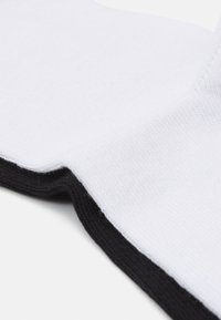 Cotton ankle sock featuring a white body with a black ribbed cuff, smooth texture, and contrasting color edge.