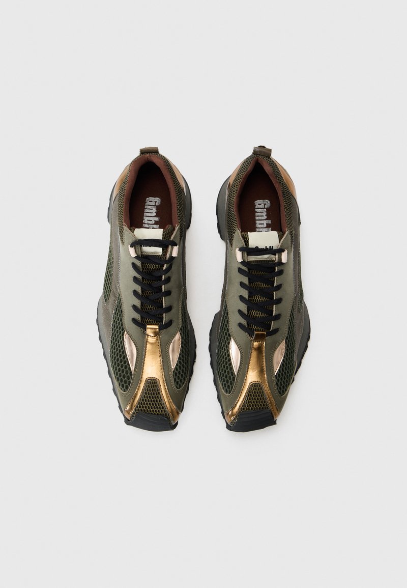 Groene mesh sport schoenen met bronzen accenten, zwarte veters en een gestructureerde zool. Bevat een bruine binnenkant en een prominent logo op de tong.