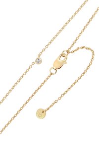 Collar de cadena de oro con un pequeño acento de diamante y una placa redonda con un logo. Cierre fuerte y eslabones delicados crean un diseño refinado.