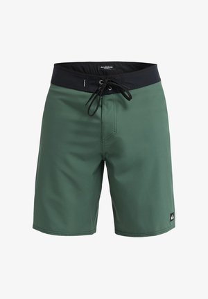 Grüne Badeshorts mit einfarbigem Design, elastischem schwarzem Bund, Kordelzugverschluss und einem kleinen Logopatch auf der unteren rechten Seite.