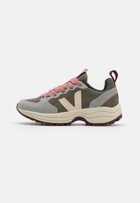 Shoe desportivo masculino em camurça cinza com detalhes em verde oliva. Apresenta atacadores cor-de-rosa, um logótipo bege e uma sola grossa e texturizada com detalhes em bordeaux.