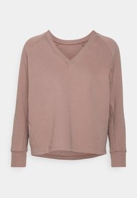 Top lungo a maniche lunghe di colore mauve chiaro con scollatura a V e maniche raglan, in tessuto morbido e con orlo arrotondato. Presenta una vestibilità rilassata e dettagli di cucitura minimali.