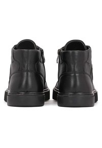 Bocanci negri din piele, cu un aspect neted, având un închidere cu fermoar pe lateral și o talpă din cauciuc negru ușor ridicată.