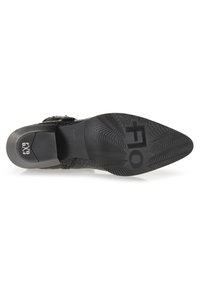 Suela de zapato de cuero negro texturizado con un patrón de relieve geométrico. Presenta un tacón medio y un logo estampado en la tapa del tacón.