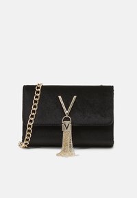 Black velvet crossbody bag with a gold chain strap, featuring a V-shaped clasp and a metallic tassel accent attached to the front.