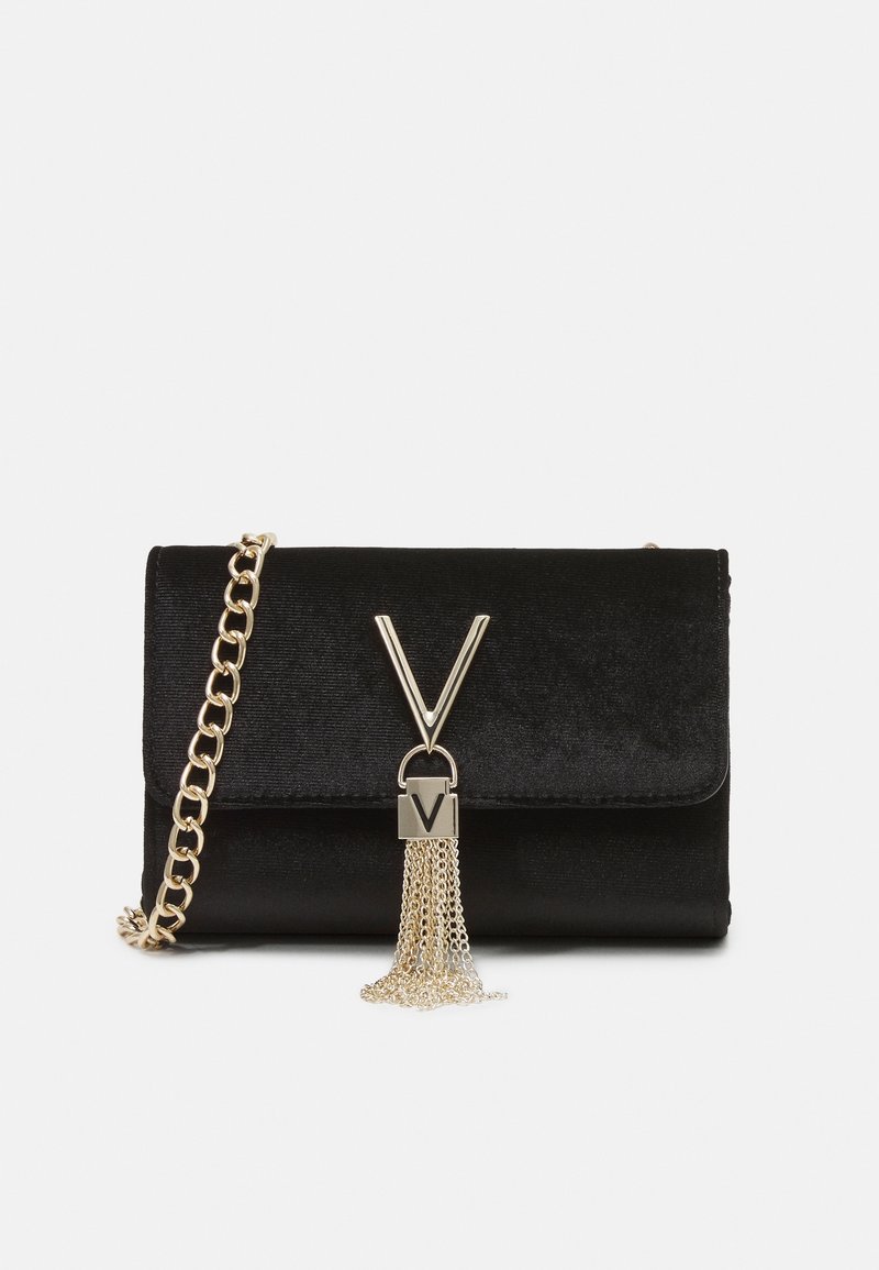 Black velvet crossbody bag with a gold chain strap, featuring a V-shaped clasp and a metallic tassel accent attached to the front.