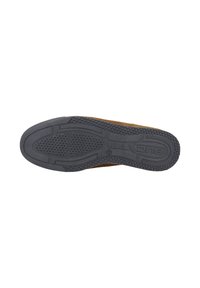 Bruine suede schoen met een zwarte rubberen zool die is voorzien van gestructureerde grippatronen, een gemodelleerd ontwerp en het merkteken aan de zijkant.