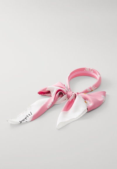 Pink silk scarf with white floral patterns, featuring a bow detail and smooth texture. Includes signature on one end.