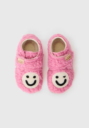 Rosa Filzschuhe mit runden, weißen Smiley-Gesicht-Anwendungen. Weiche Textur, Rutsch-On-Design und ein kleines Etikett an der Seite.