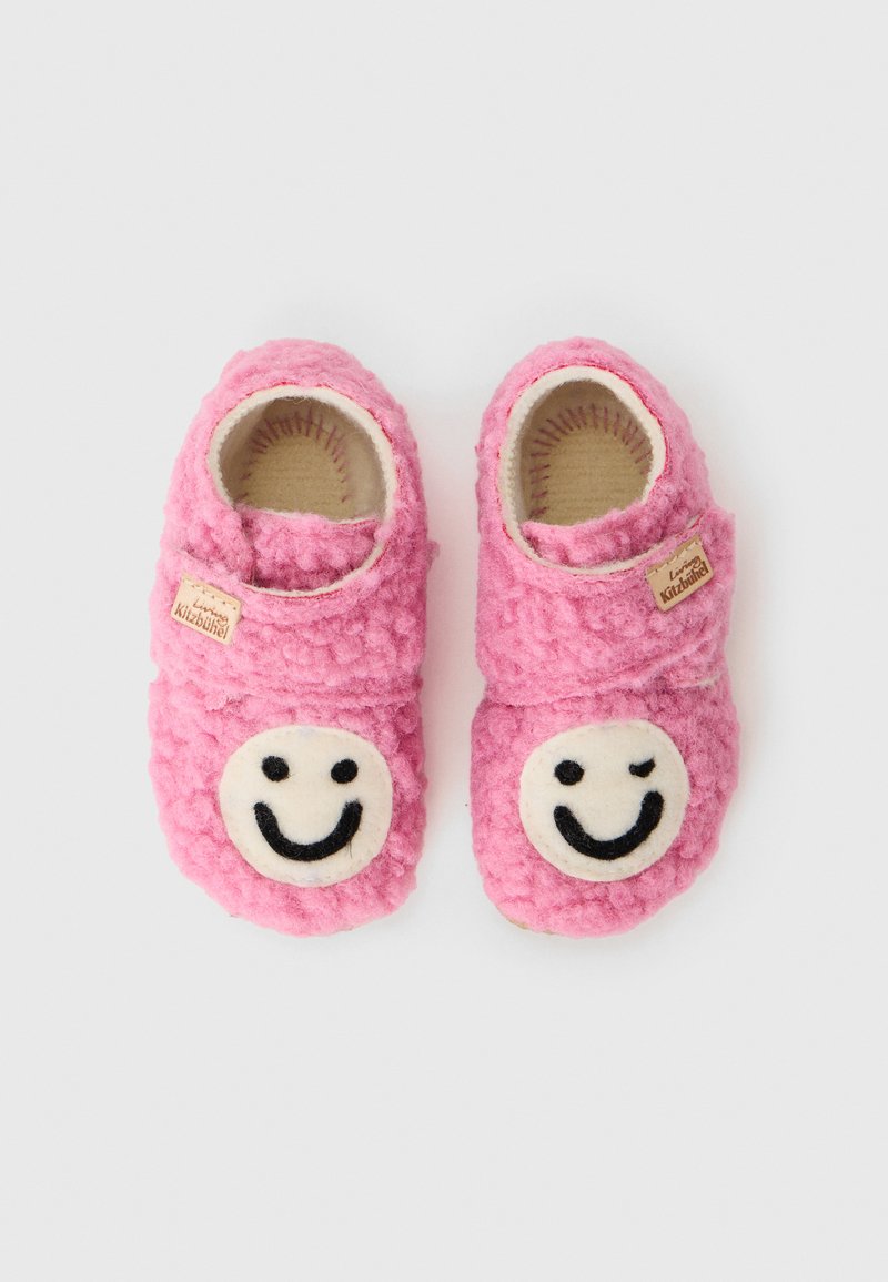 Rosa filttofflor med runda, vita smiley face-applikationer. Mjuk textur, att glida på design och en liten tagg på sidan.