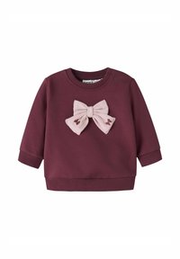 Felpa color bordeaux con un fiocco in tessuto rosa sul davanti. Maniche lunghe, polsini e orlo a costine, texture morbida e dettagli ricamati.