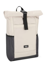 Zaino roll-top in tela beige chiaro con chiusura a strap nera. Presenta una base grigia scura e tasche laterali. Inclusa una discreta dettaglio del logo.
