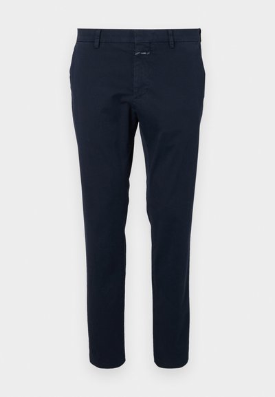 Tummansininen puuvillachino-housut, joissa on slim fit, tasapohja ja vetoketjuhäntä. Varustettu sivutaskuilla ja takataskulla, jossa on pieni brändilogo.