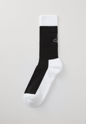 Fekete-fehér bokazokni bordázott mintával. A fekete rész a lábujjtól a közepéig terjed, míg a fehér rész a tetején található.