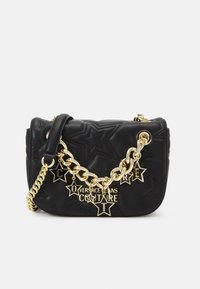 Sac à épaule en cuir noir avec un motif étoile embossé, une bandoulière en chaîne dorée et des pendentifs de logo. Design compact avec une fermeture éclair.