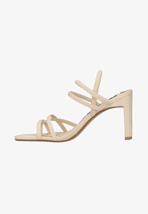Beżowe sandały na wysokim obcasie z cienkimi paskami, o gładkim wykończeniu, z otwartym noskiem i smukłym obcasem, z wieloma cienkimi paskami na stopie.