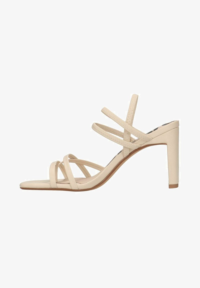 Sandale à talon haut beige à lanières avec une finition lisse, un bout ouvert et un talon élancé, comportant plusieurs fines lanières sur le pied.