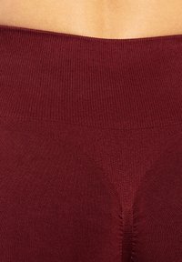 Bordeaux seamless leggings met een brede geribbelde tailleband en een gladde textuur, met een geaccentueerd geometrisch patroon in het midden.