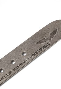 Section de ceinture en cuir gris avec trois trous et texte embossé "A. P.M.E LEGEND" et emblème ailé au-dessus du texte sur fond blanc.