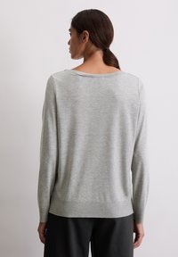 Helles graues langärmliges Strickpullover mit weitem Ausschnitt, geripptem Saum und Bündchen, der eine glatte Textur und einen lässigen Schnitt aufweist.