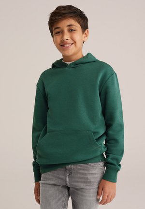Grön huvtröja med framficka, snörning i huvan, ribbade muddband och nederkant. Matcher med grå jeans. Slät textur.
