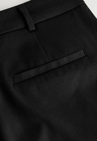Musthave mustandid mustkommunikatsioonis mustad riidest püksid, millel on sile tekstuur, lame tagatasku ja vööde auk.