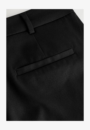 Pantalons en tissu noir avec une texture lisse, dotés d'une poche arrière plate et d'une boucle à la taille.