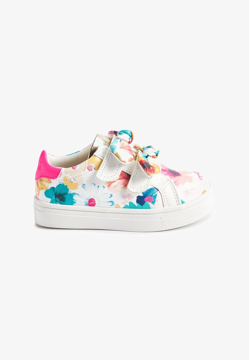 Baskets blanches pour enfants avec imprimé floral coloré, deux attaches à nœud en tissu, patch rose au talon et semelle en caoutchouc blanche.