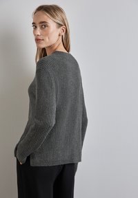 Maglione grigio a coste con colletto rotondo, maniche lunghe e vestibilità comoda; presenta un tessuto testurizzato e spacchi laterali all'orlo.