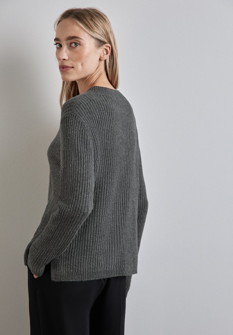 Maglione grigio a coste con colletto rotondo, maniche lunghe e vestibilità comoda; presenta un tessuto testurizzato e spacchi laterali all'orlo.