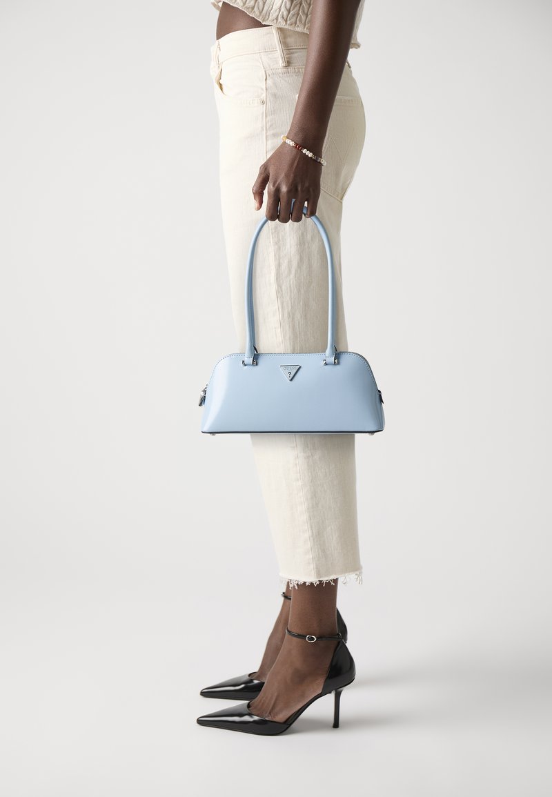Borsa a mano azzurro chiaro con una texture liscia, forma strutturata e manici corti. Presenta un logo triangolare e due piccole cerniere.