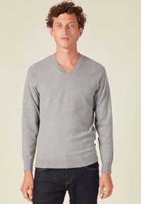 Maglione grigio a V realizzato in materiale di maglia, caratterizzato da maniche lunghe e un design aderente con polsini e orlo a costine.