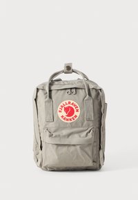 Grå ryggsäck tillverkad av slitstarkt tyg med en stor framficka, webbade axelremmar och en rund logopatch i röd och gul.